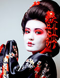 young pretty geisha in black kimono among sakura, asian ethno close up