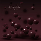 Dark chocolate balls on abstract background.