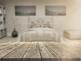 3D wooden table looking out to a defocussed bedroom interior