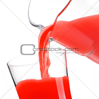 Pouring delicious red juice in glass