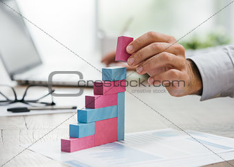 Businessman building a growing financial graph
