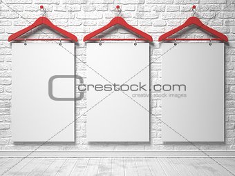 Cloth hangers and white canvas on the white painted brick wall