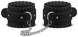 Black leather handcuffs on chain. Accessory toy for fetish bdsm game