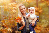 Happy mother with baby in autumn park