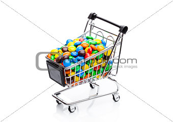 Round coated sweet candies in shopping cart
