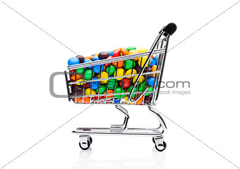 Round coated sweet candies in shopping cart