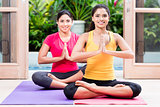 Two women in lotus position during yoga practice