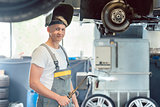 Portrait of a handsome auto mechanic looking at camera with conf