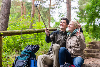 Man and woman hiking taking selfie with phone