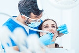 Young woman during painless oral treatment in the modern dental clinic