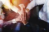 Business people joining hands in the office. concept of teamwork and partnership. double exposure