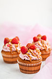 Raspberry and caramel cupcakes on white background