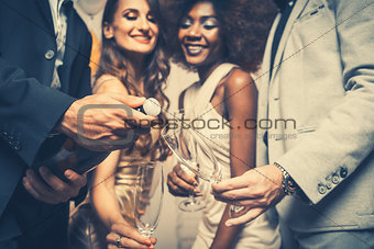 Man opening champagne bottle on celebration in club
