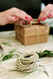 woman tying a string around a gift