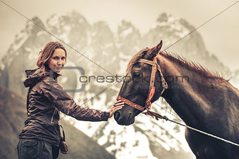 Portrait of young pretty cheerful woman with horse
