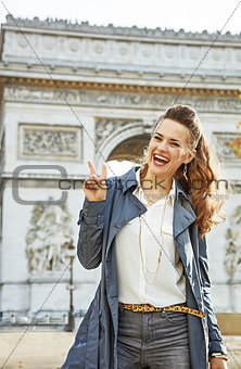 fashion-monger near Arc de Triomphe showing victory gesture