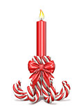 Christmas decoration made of candy canes, ribbon bow and candle 