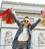 woman with shopping bags rejoicing near Arc de Triomphe, Paris