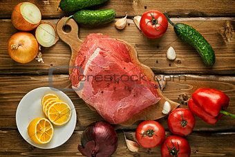 Raw beef with vegetables on wooden boards