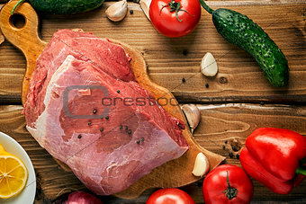 Raw beef with vegetables on the wooden table