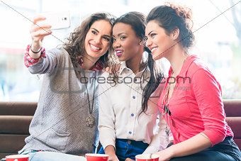 Young women in cafe taking selfie