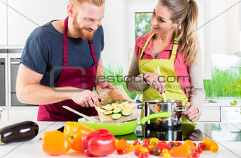 Man and woman cooking vegetarian dish together