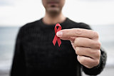 man with red ribbon for the fight against AIDS
