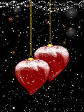 Christmas baubles heart shaped and snow on festive background