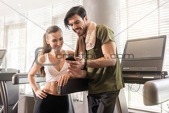 Young couple smiling while communicating on the mobile phone dur