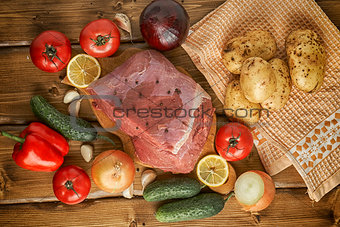 Raw beef with potatoes and vegetables on wooden boards