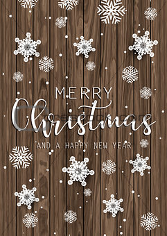 Christmas text and snowflakes on wooden texture