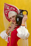 Close-up. Woman in a folk russian dress holds a jug