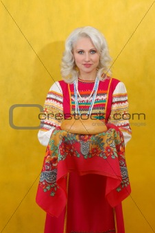Russian woman in a folk russian dress Holds a bread on yellow background