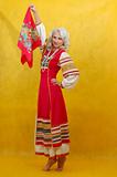Russian woman in a folk russian dress waves a scarf