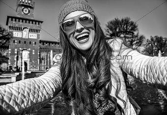 happy trendy traveller woman in Milan, Italy taking selfie