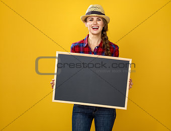 smiling woman grower isolated on yellow showing blank board