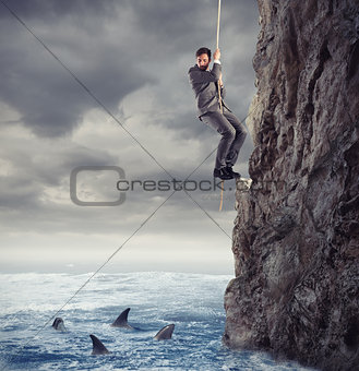 Businessman is likely to fall into the sea with sharks. concept of problems and difficulty in business