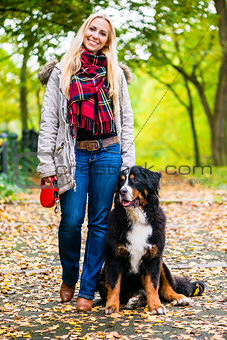 Woman walking the dog on leash in park