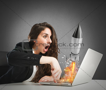Businesswoman launches rocket from a laptop. concept of company startup