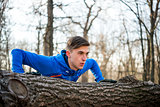 Male Runner Doing Push Up on the Log in the Park in Sunny Autumn Morning. Healthy Lifestyle and Sport Concept.
