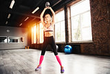 Blonde girl working out at the gym with a kettlebell