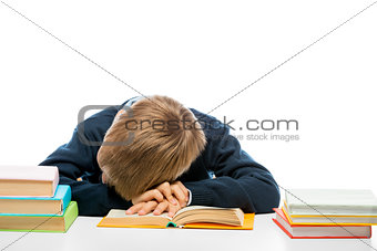 a tired schoolboy fell asleep while reading a book at the table