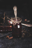 raspberry jam in a glass jar with an iron spoon inside 