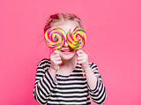 Kid girl with lollypops in front her eyes