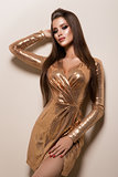Beautiful woman with professional make up. Gold dress
