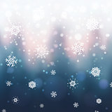 Abstract Christmas background with blurred winter forest, snowflakes and bokeh. Sunset over winter trees.