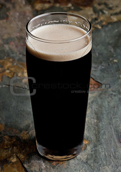 Glass of stout beer top with white foam