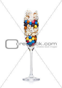 Popcorn and round chocolate candies in glass