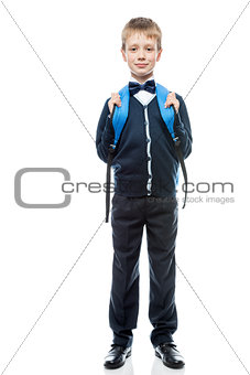 vertical portrait of a schoolboy with a backpack in the form in 