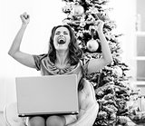 Happy young woman with credit card and laptop rejoicing
